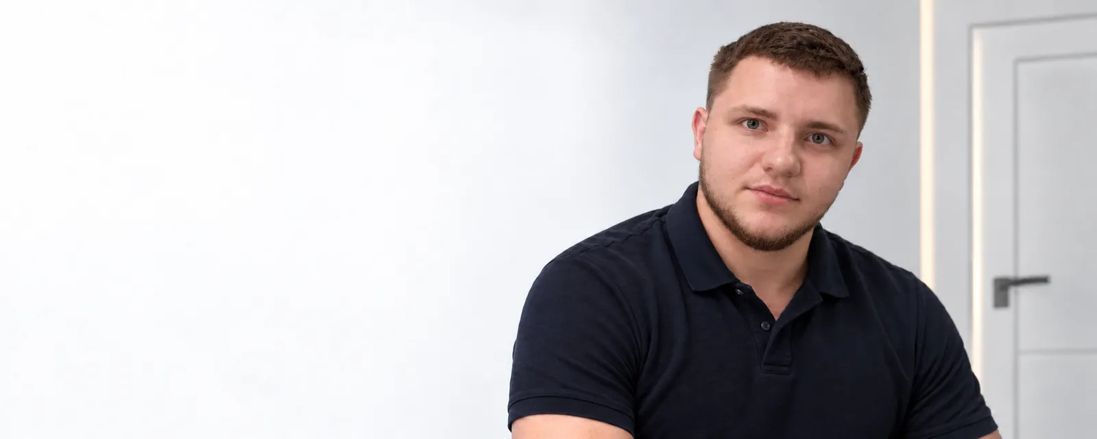 Роман Маврин, руководитель Интер-Двери, в светлом интерьере с дверью